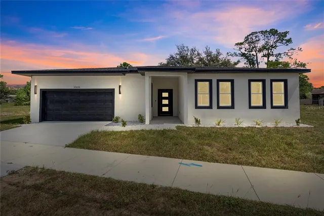 a front view of a house with a yard and garage