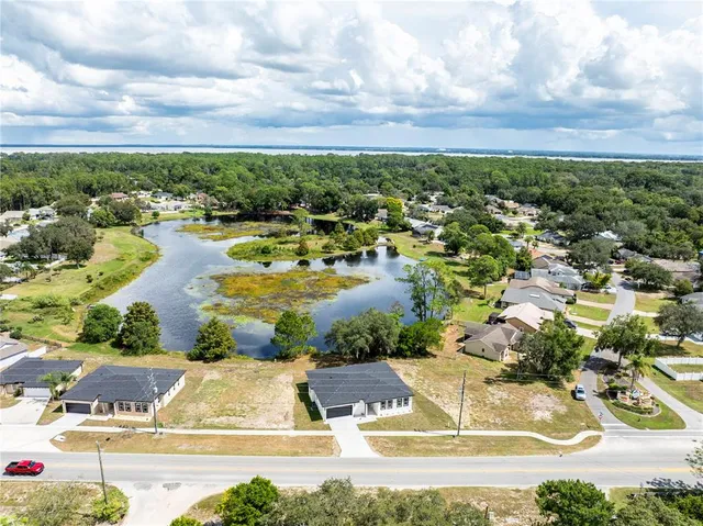an aerial view of residential houses with outdoor space and swimming pool