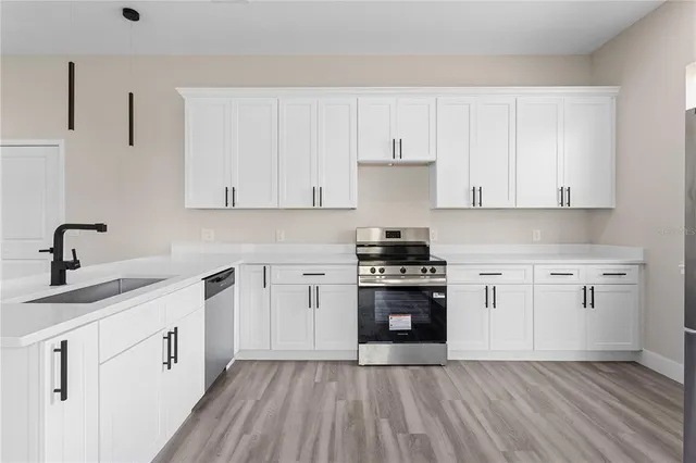 a kitchen with cabinets appliances and a sink