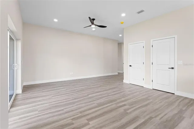 a view of an empty room with wooden floor