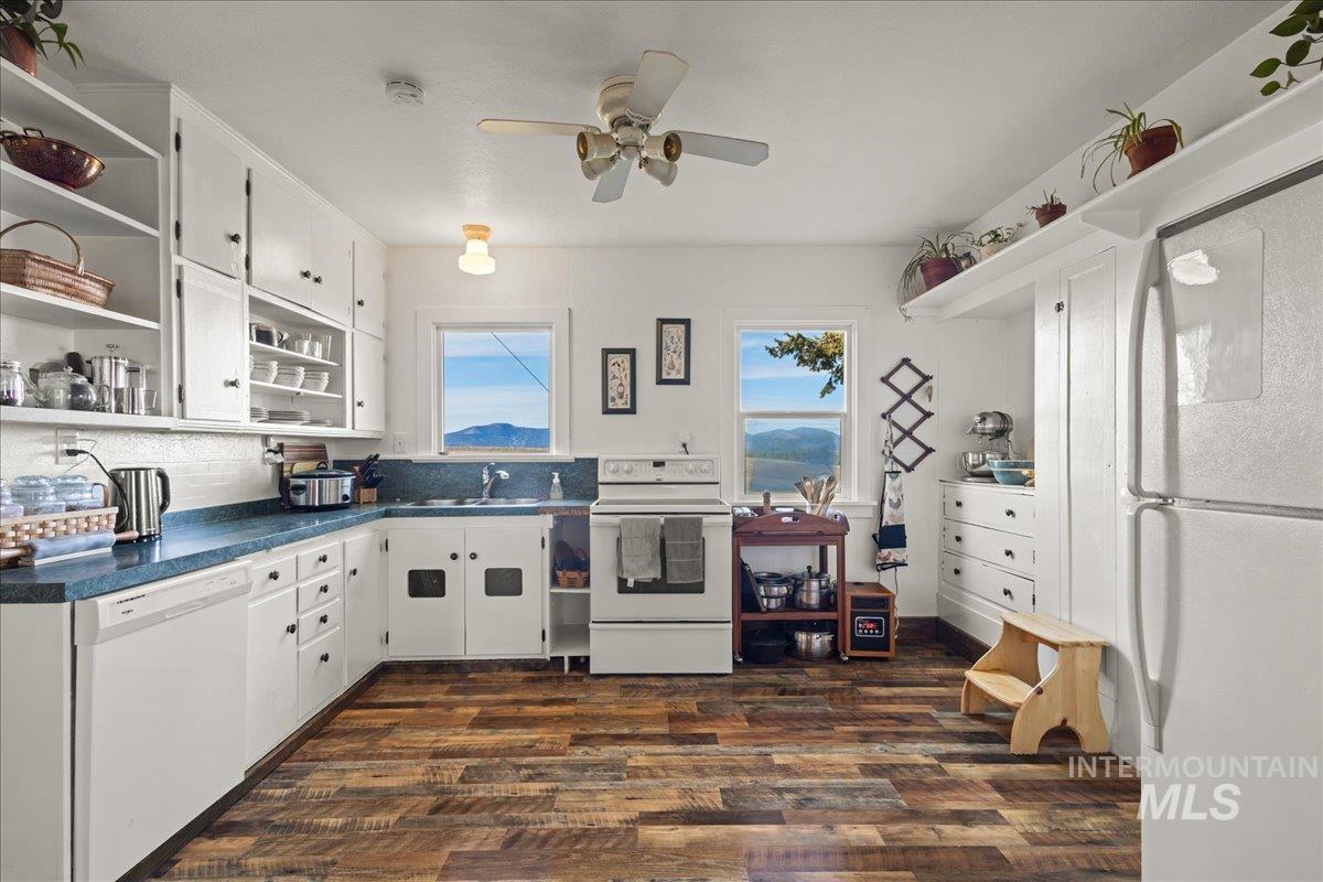 19454 Idaho Road Worley, ID 83876 - Photo 11 of 50 Kitchen with open shelves, white cabinets, white appliances, dark wood-style flooring, and dark countertops