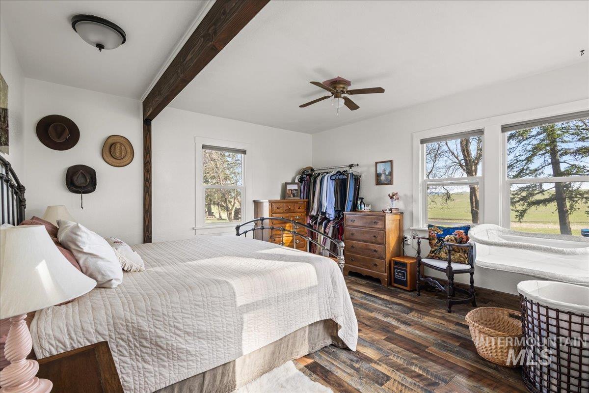 19454 Idaho Road Worley, ID 83876 - Photo 16 of 50 Bedroom featuring dark wood-style floors, beamed ceiling, and a ceiling fan