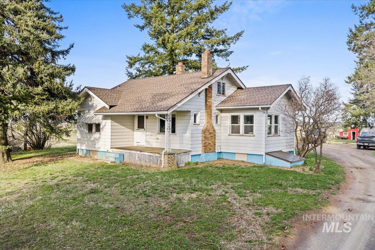 19454 Idaho Road Worley, ID 83876 - Photo 2 of 50 Bungalow-style house with a front yard, a chimney, and a shingled roof