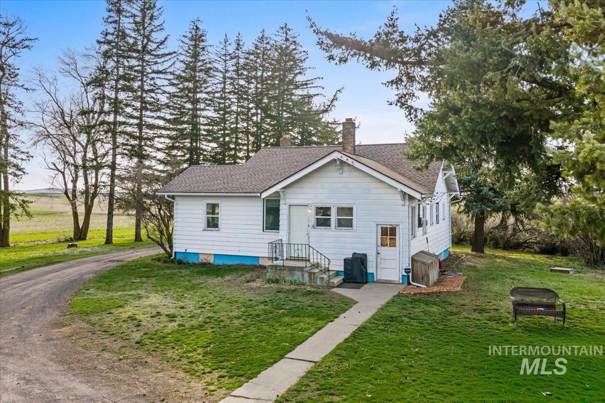 19454 Idaho Road Worley, ID 83876 - Photo 29 of 50 Rear view of house featuring a yard, a chimney, and roof with shingles