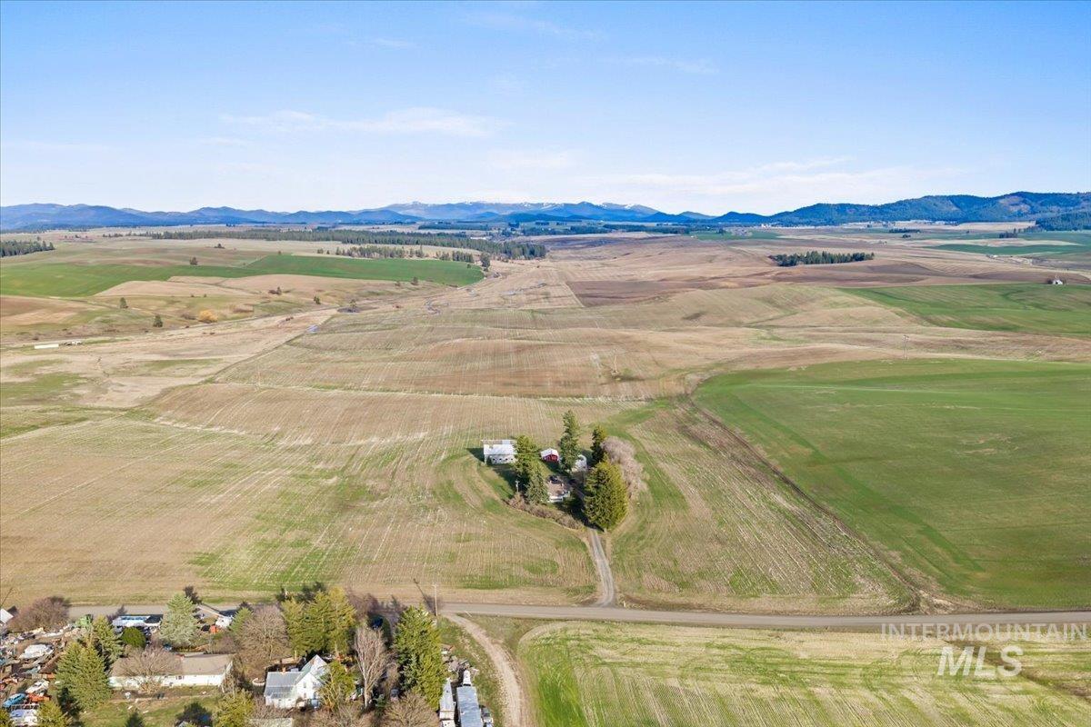 19454 Idaho Road Worley, ID 83876 - Photo 32 of 50 Aerial view of sparsely populated area with a mountainous background and large plots for crops
