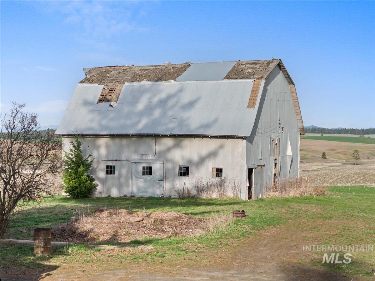 19454 Idaho Road Worley, ID 83876 - Photo 39 of 50 View of property exterior with a gambrel roof, an outdoor structure, and a barn