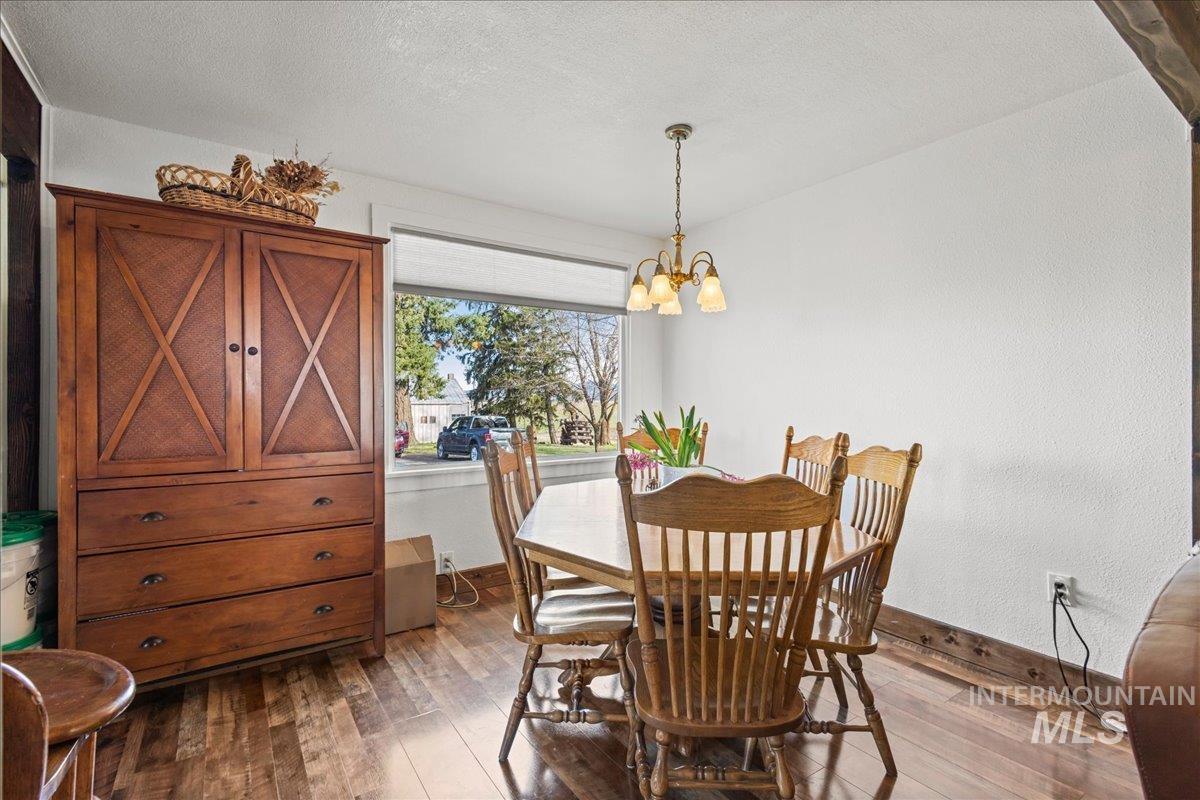 19454 Idaho Road Worley, ID 83876 - Photo 10 of 50 Dining room with hanging lights, a textured ceiling, dark wood-type flooring, and a textured wall