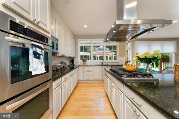 a large kitchen with stainless steel appliances granite countertop a lot of counter space