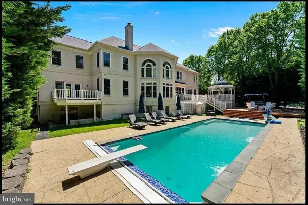 a front view of a house with swimming pool having outdoor seating