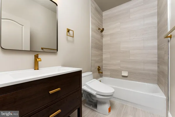 a bathroom with a sink a toilet a mirror and shower