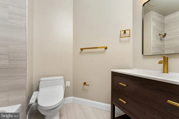 a bathroom with a toilet a sink and mirror