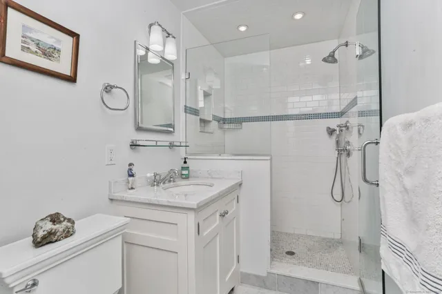 a bathroom with a sink vanity granite shower and a mirror