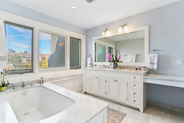 a bathroom with a tub sink and mirror