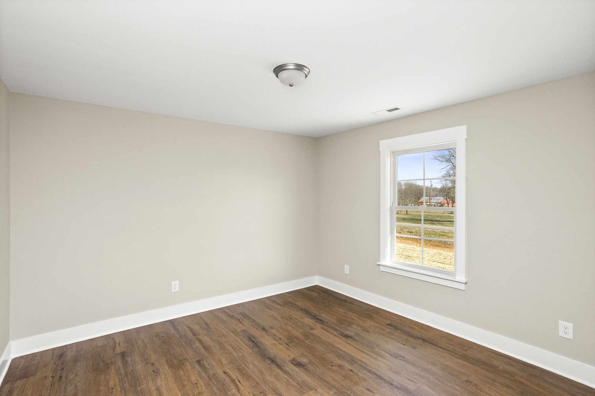 381 Copperas Creek Road Tullahoma, TN 37388 - Photo 21 of 44 an empty room with wooden floor and windows