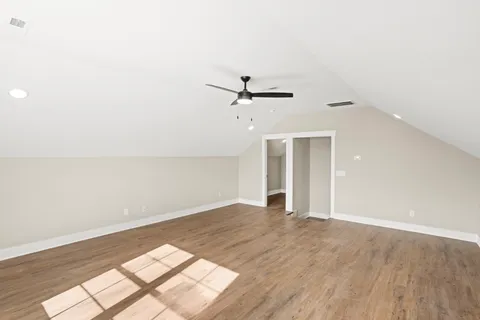an empty room with a ceiling fan and window