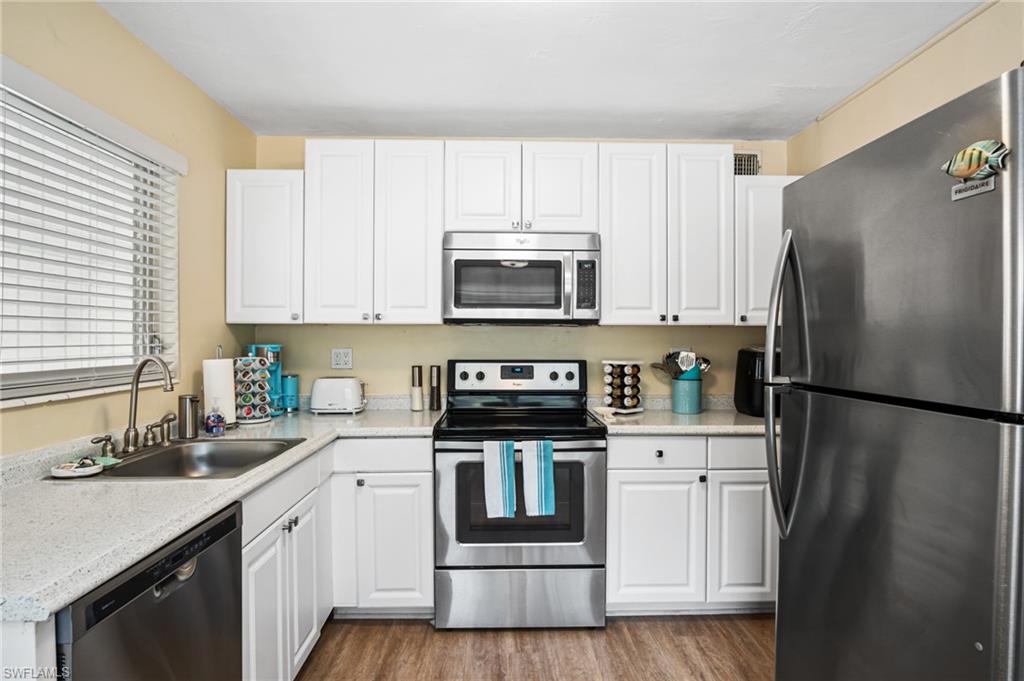 1097 Sperling Avenue Naples, FL 34103 - Photo 12 of 37 a kitchen with a sink a microwave a refrigerator and cabinets