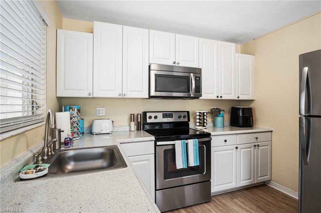 1097 Sperling Avenue Naples, FL 34103 - Photo 13 of 37 a kitchen with granite countertop a sink a stove and cabinets