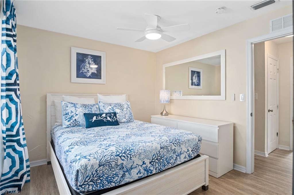 1097 Sperling Avenue Naples, FL 34103 - Photo 20 of 37 a bedroom with a large bed and a chandelier