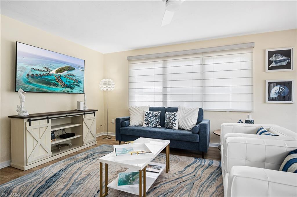 1097 Sperling Avenue Naples, FL 34103 - Photo 2 of 37 a living room with furniture a flat screen tv and a fireplace