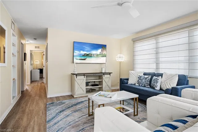 a living room with furniture a wooden floor and a stove