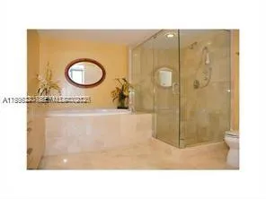 a bedroom with a bed large windows and a balcony