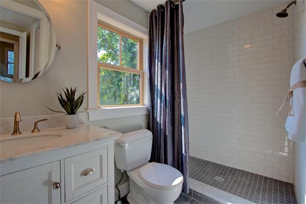 6 Gerring Road Gloucester, MA 01930 - Photo 20 of 22 a bathroom with a granite countertop toilet a sink a mirror and a window