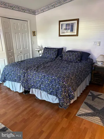 a living room with a bed furniture and a wooden floor