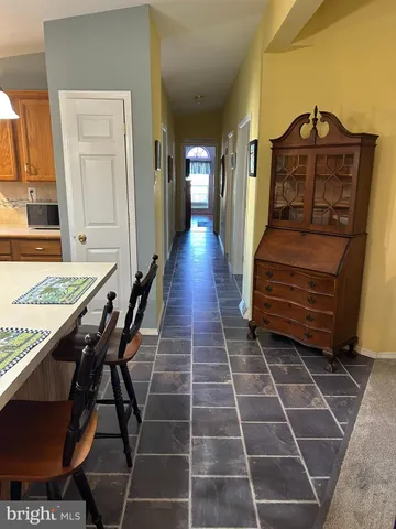 a view of a hall way with furniture and wooden floor