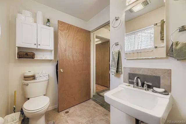a bathroom with a sink a toilet and a mirror