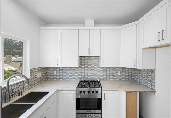 a kitchen with a sink a stove and cabinets