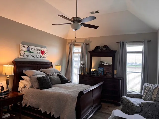 a bedroom with a bed and wooden floor