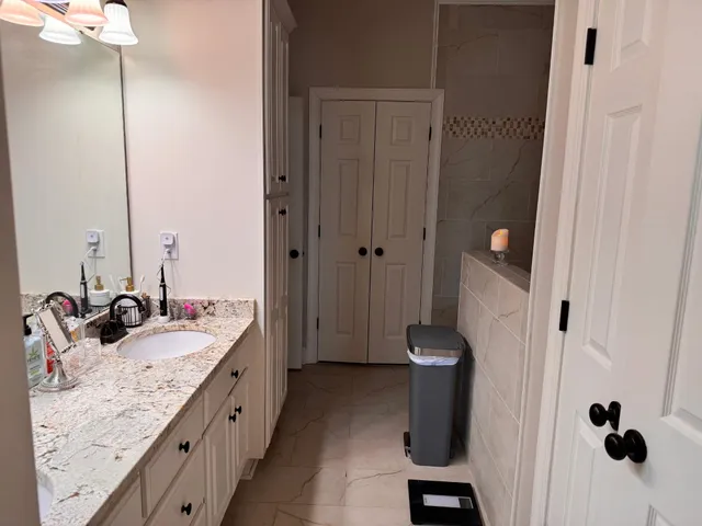 a bathroom with a granite countertop sink toilet and shower