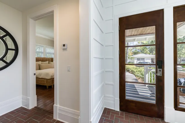 a view of a hallway with wooden floor and a bedroom
