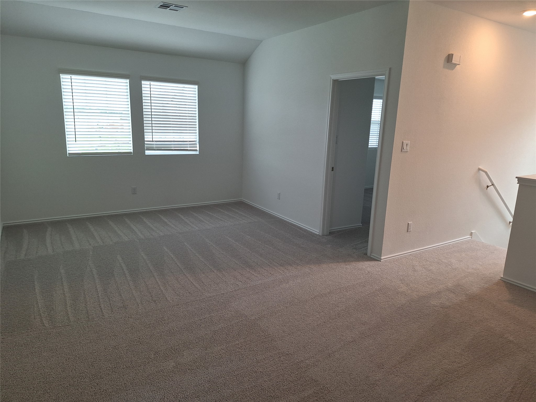 18001 Prairie Falcon Way Pflugerville, TX 78660 - Photo 30 of 38 Spacious room featuring neutral carpet and abundant natural light from two windows