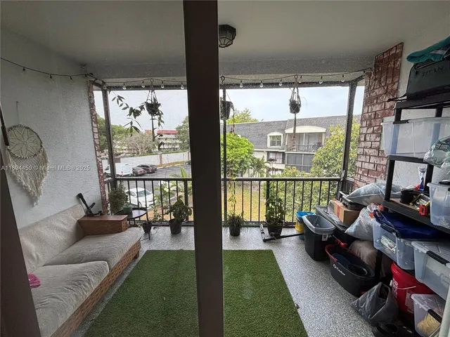 a living room with furniture floor to ceiling window and a flat screen tv