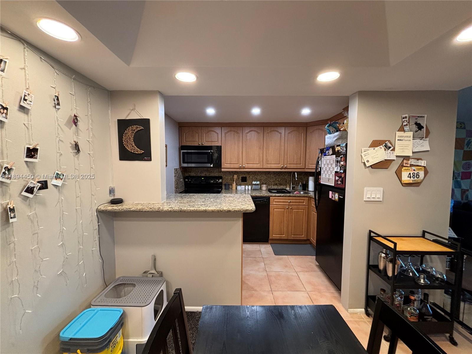 3650 Inverrary Drive, Unit 3YG Lauderhill, FL 33319 - Photo 21 of 38 a kitchen with stainless steel appliances kitchen island granite countertop a refrigerator and a stove top oven