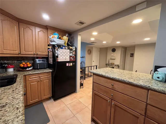 a kitchen with granite countertop stainless steel appliances and refrigerator