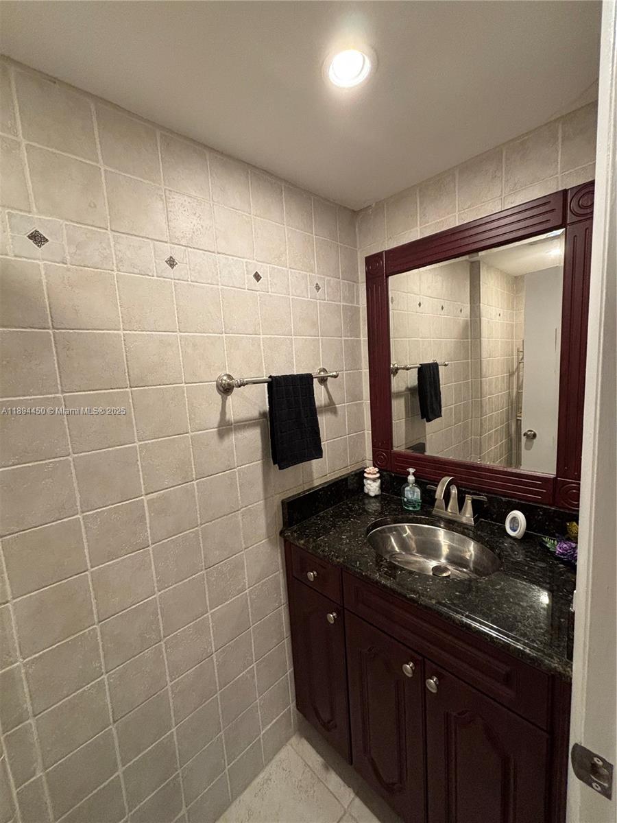 3650 Inverrary Drive, Unit 3YG Lauderhill, FL 33319 - Photo 27 of 38 a bathroom with a double vanity sink and mirror