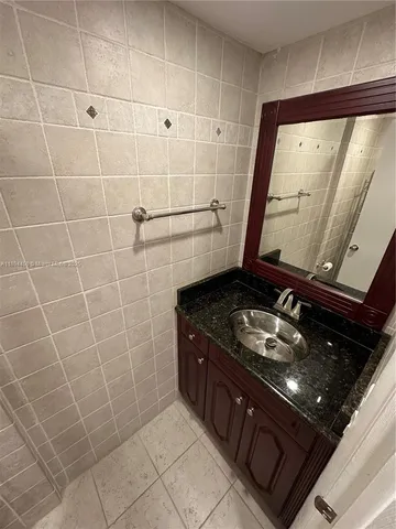 a bathroom with a granite countertop sink a stove and shower