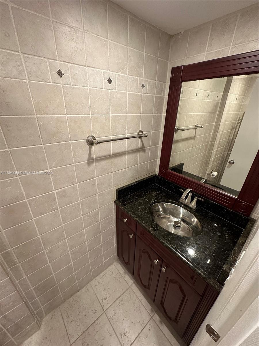 3650 Inverrary Drive, Unit 3YG Lauderhill, FL 33319 - Photo 6 of 38 a bathroom with a granite countertop sink a stove and shower