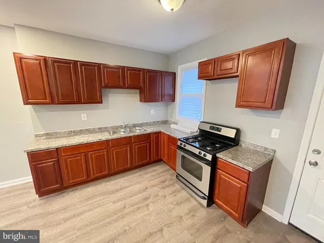 a kitchen with granite countertop wooden cabinets and stainless steel appliances