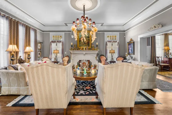 a living room with furniture a chandelier and a fireplace
