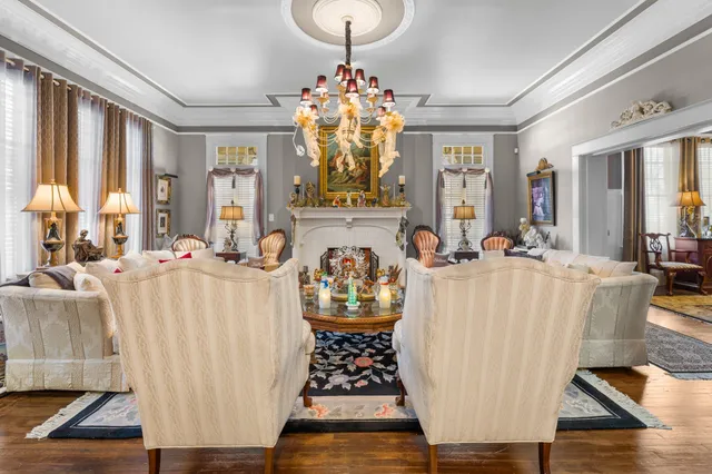 a living room with furniture a chandelier and a fireplace
