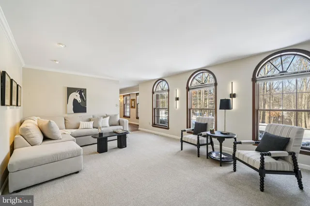 a living room with furniture with floor to ceiling windows