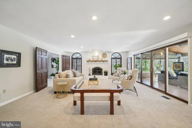 a living room with furniture a large window and a fireplace