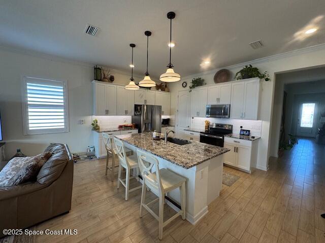 2115 Trift Bridge Circle Melbourne, FL 32940 - Photo 6 of 34 a kitchen with stainless steel appliances granite countertop a stove top oven a refrigerator a sink and a dining table with wooden floor