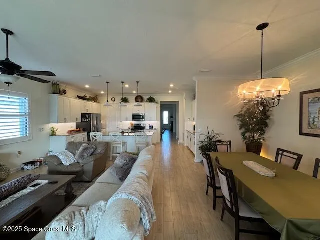 a view of a dining room and livingroom with furniture wooden floor a chandelier