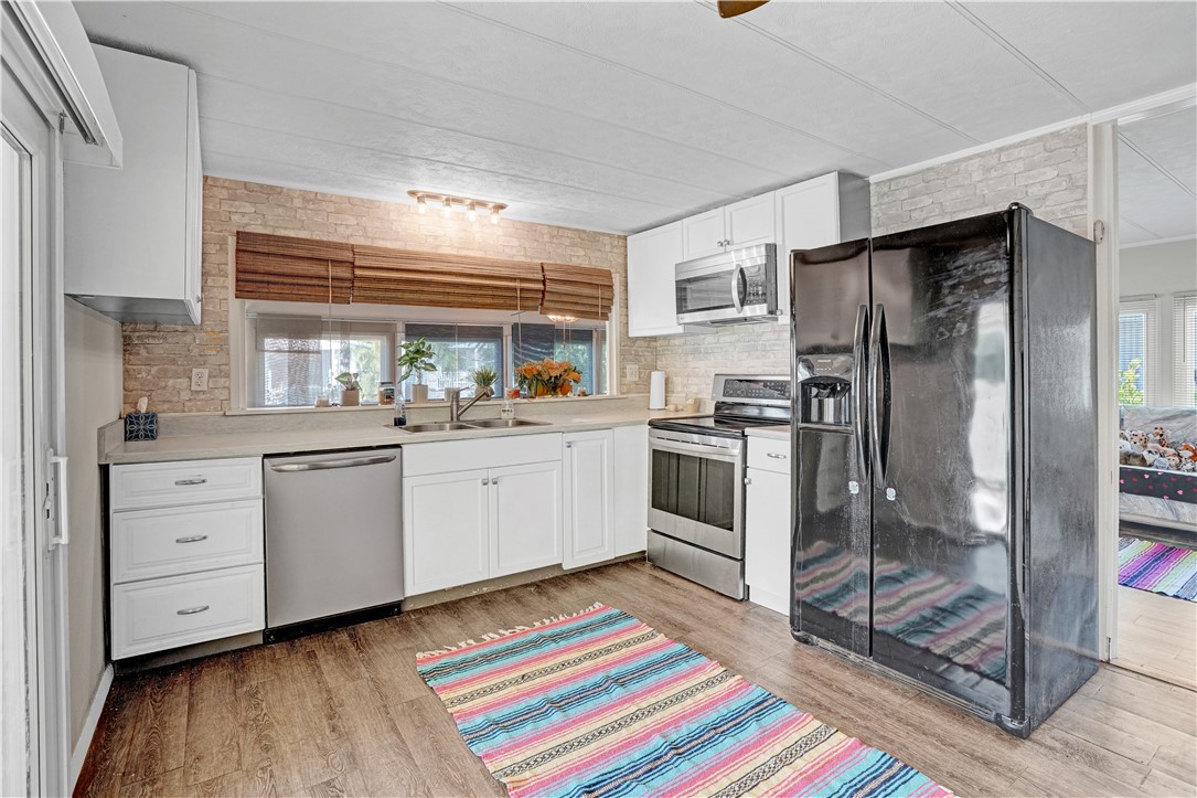 a kitchen with white cabinets and appliances