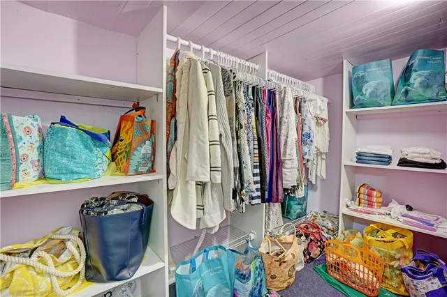 a view of walk in closet with clothes and shoes