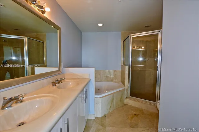 a bathroom with a sink a large mirror a toilet and bathtub
